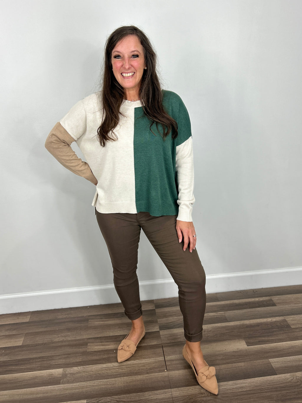 Andrew colorblock relaxed fit sweater paired with brown jeggings and flat camel color shoes.