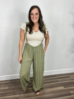 Load image into Gallery viewer, Outfit styled with the banks ivory and brown striped butterfly cap sleeve top layered under the cardigan jumpsuit in green.
