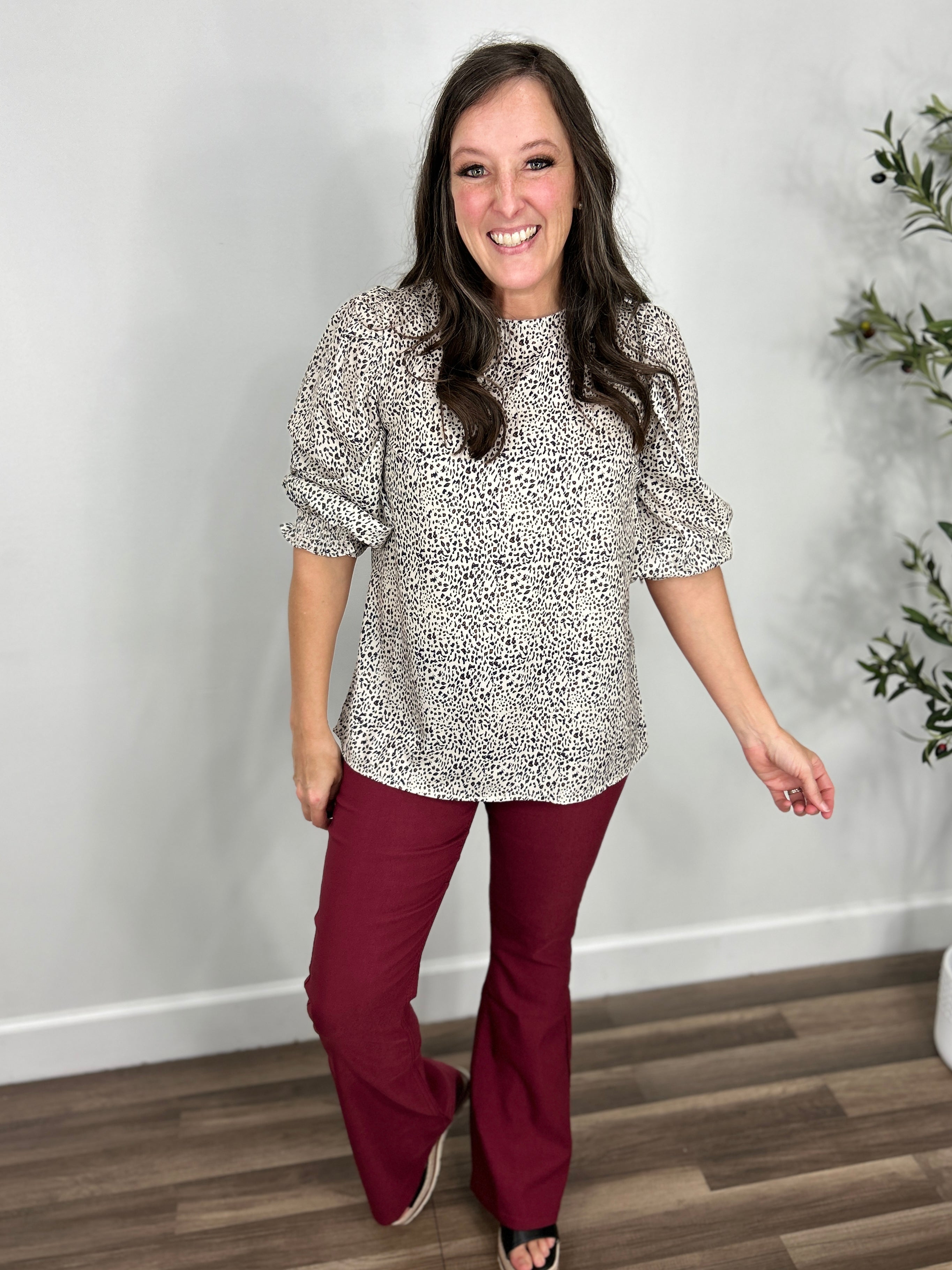 women's small leopard print 3/4 sleeve top paired with maroon flare pants and black wedge sandals.