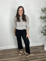 Load image into Gallery viewer, Bonnie Leopard print puff sleeve top front tucked into black cropped denim jeans and paired with black wedge sandals.
