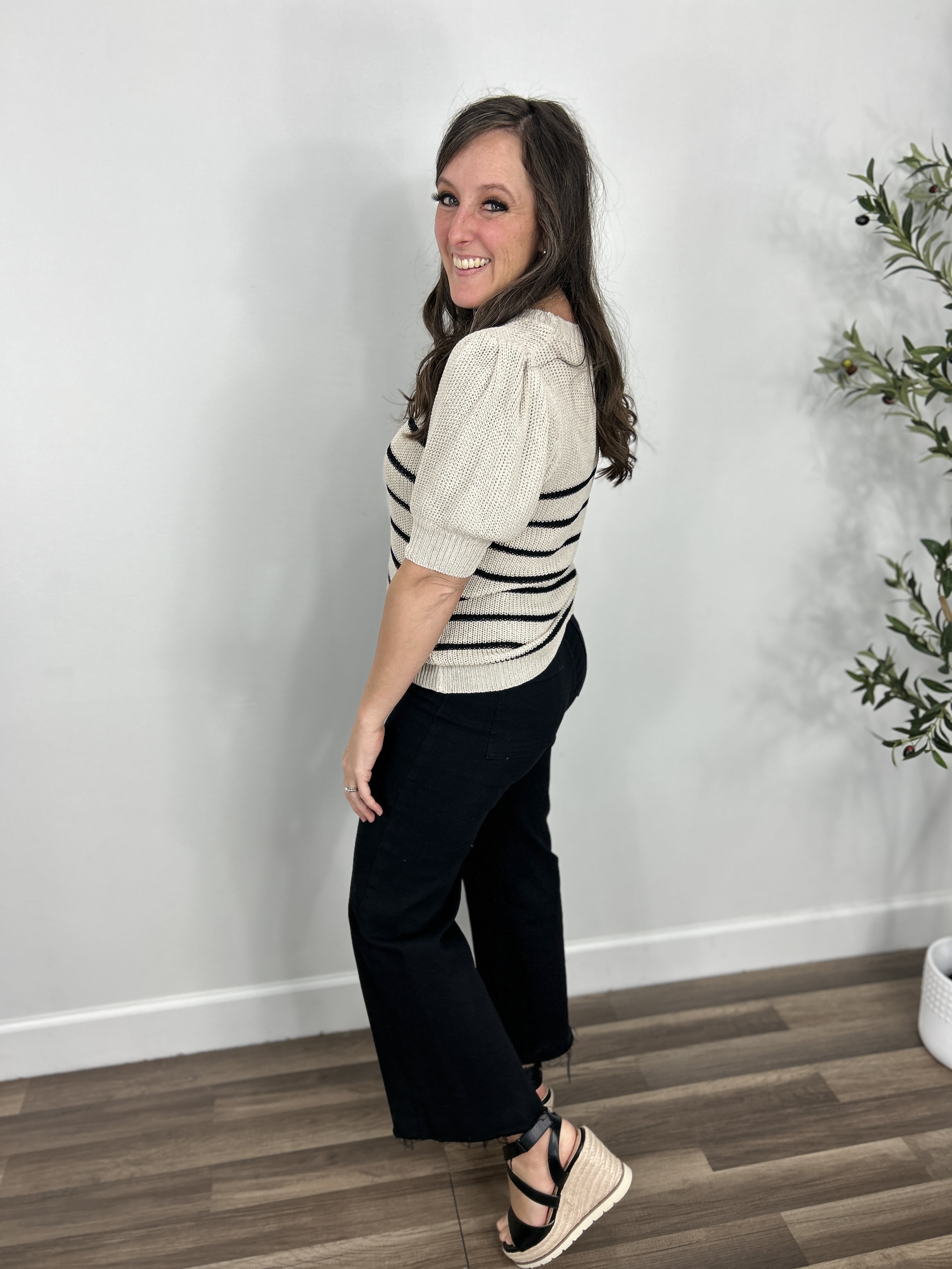 Women's carrie striped knit sweater top side view of puff sleeve paired with black denim pants and black wedge shoes.