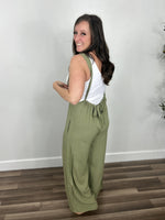 Load image into Gallery viewer, Women&#39;s green jumpsuit back view of bow tie detailing.
