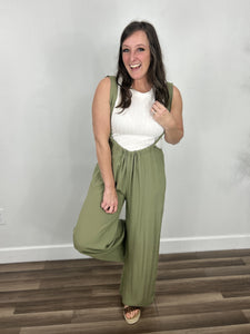 Carrigan casual wide leg jumpsuit outfit styled with cream tank and wedge sandals.