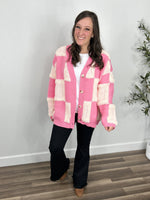 Load image into Gallery viewer, Womens checkered pink and ivory button up cardigan styled with black flare leg pants.
