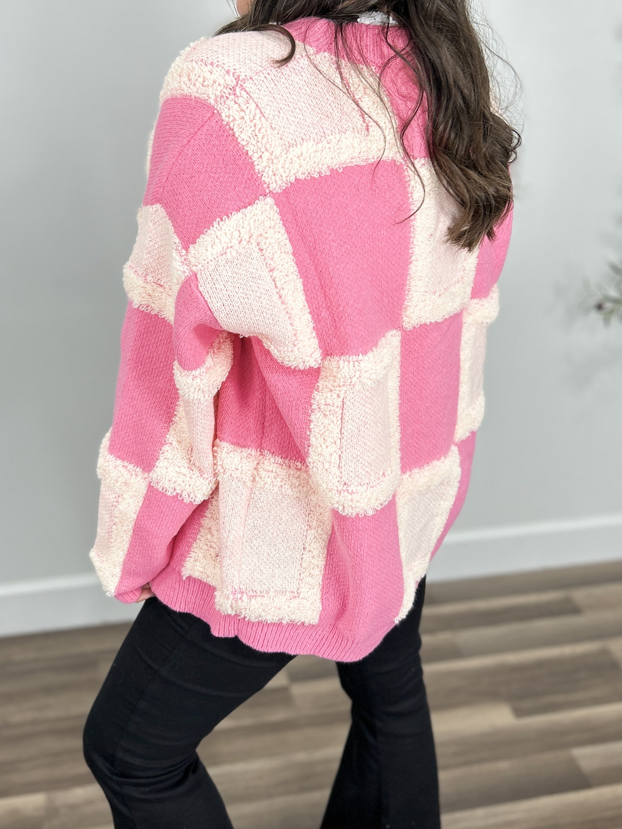Checkered women's cozy cardigan back view of pink and ivory checkered pattern.