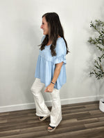 Load image into Gallery viewer, Women&#39;s chambray v neck short sleeve babydoll top paired with white flare pants and black sandals.
