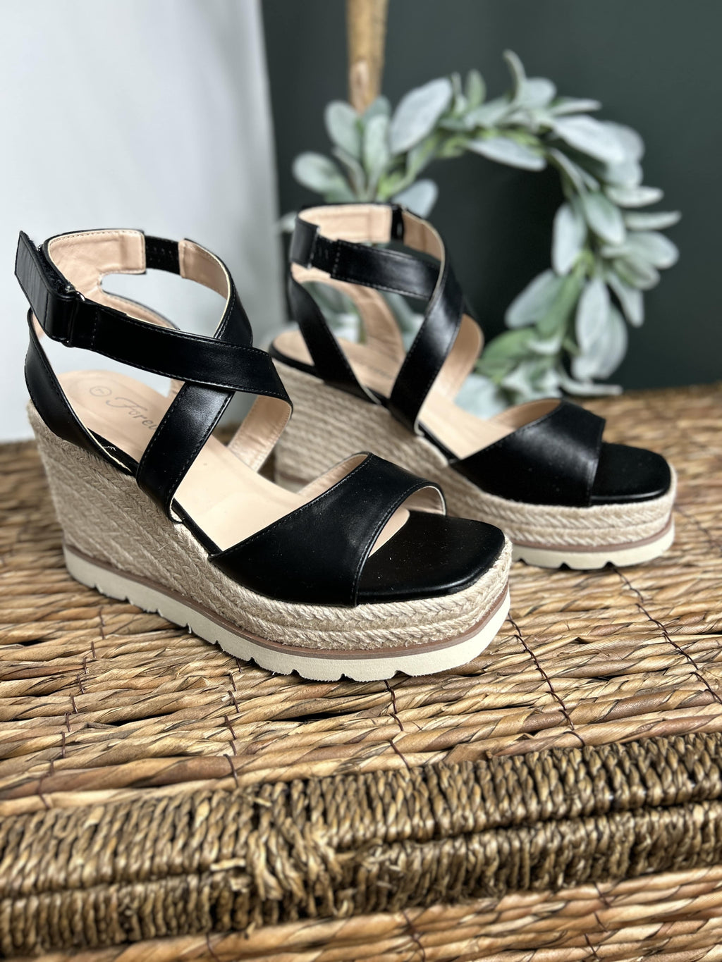 Elvira black strap wedge sandal with a criss cross strap and 4 inch heel.