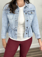 Load image into Gallery viewer, Upclose view of the Emma Peplum light wash button down denim jacket with double front breast pockets.
