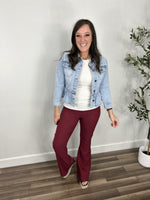 Load image into Gallery viewer, Outfit styled with the Emma Peplum Lightwash Denim Jacket. Layered over a ivory tank top and paired with maroon stretch flare pants.
