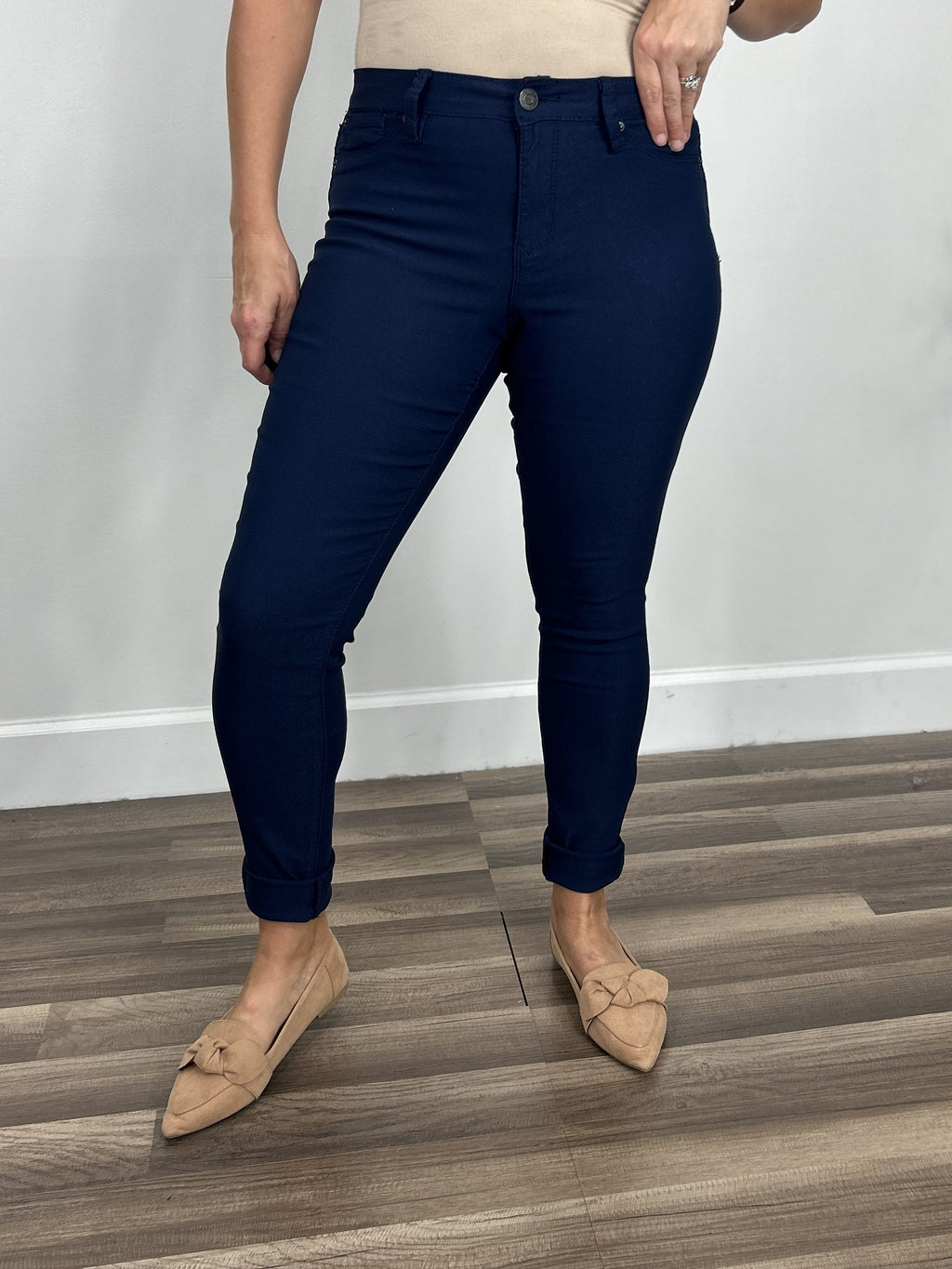 Women's navy blue skinny pants with a single button zipper fly and faux front pockets.