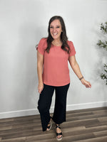 Load image into Gallery viewer, Women&#39;s round neck coral short sleeve top styled with black denim pants and black wedge sandals.

