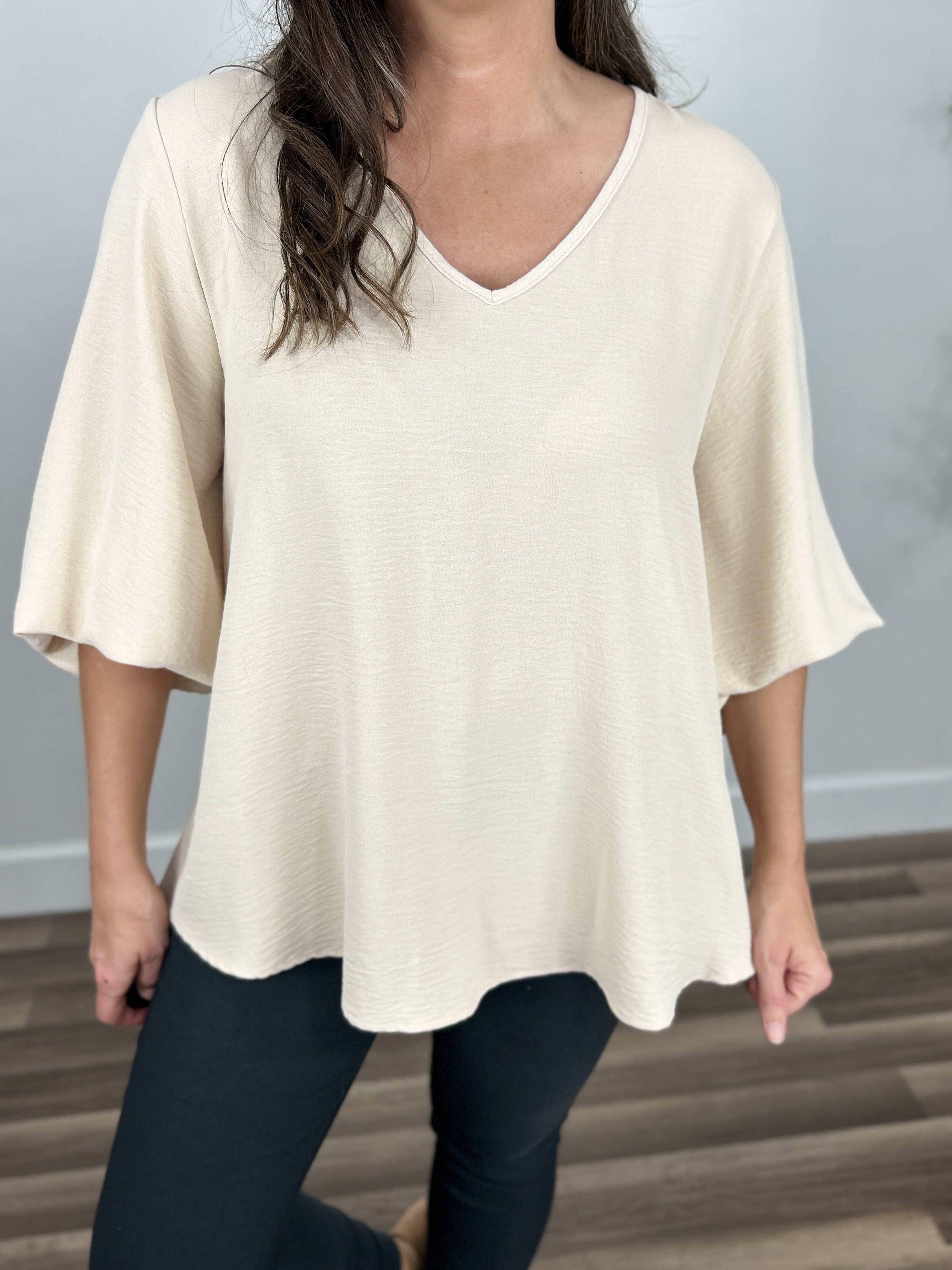 Upclose view of the women's ivory three quarter sleeve v neck top.