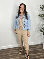 Load image into Gallery viewer, Women&#39;s taupe sleeveless jumpsuit paired with a lightwash denim jacket and black wedge sandals.
