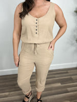 Load image into Gallery viewer, Closer view of the wavy cotton material on the Kaytan Pocketed Sleeveless jumpsuit with waist tie and button down detailing on chest.
