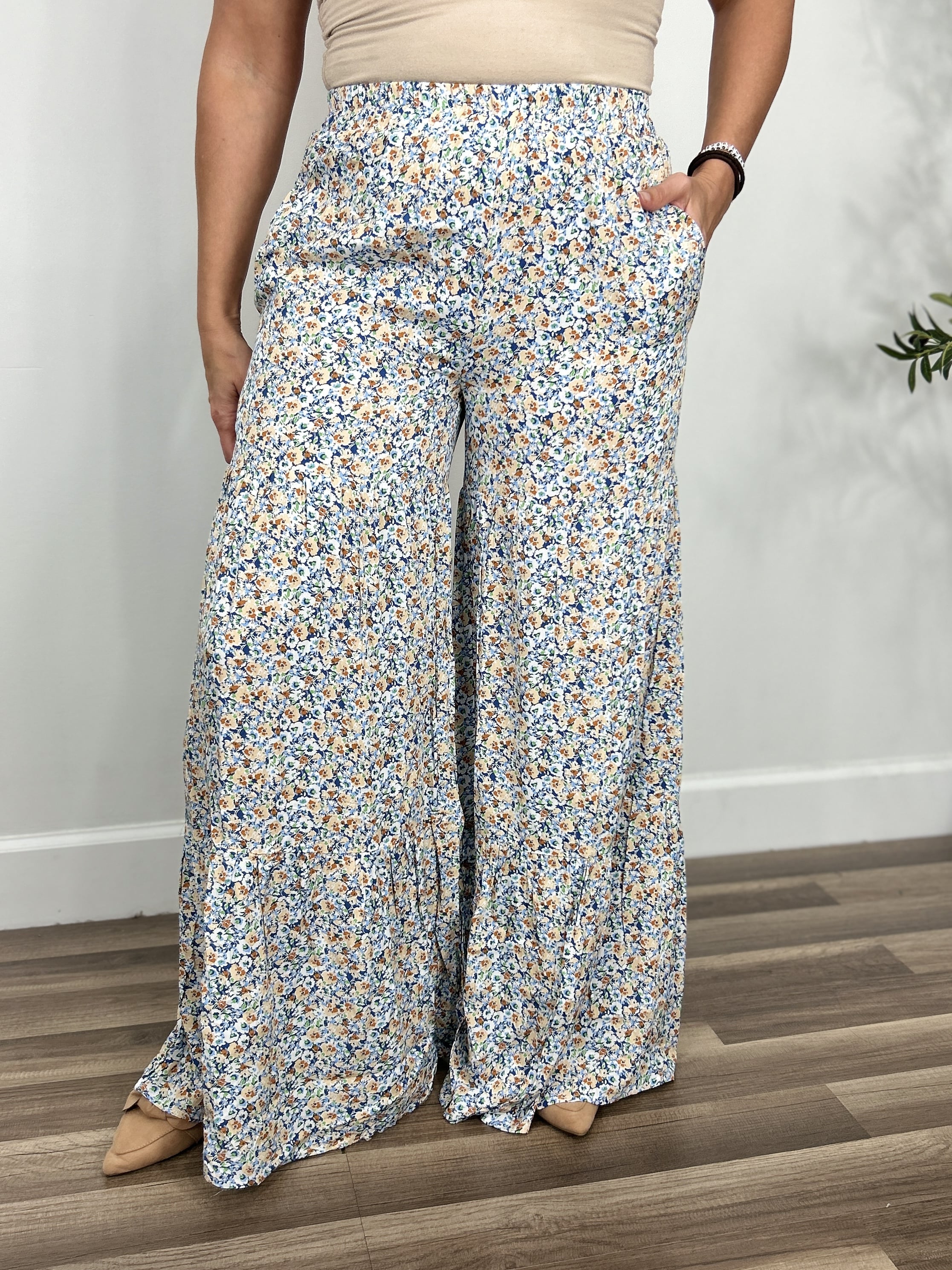 Women's multi color floral pants with flared wide legs and functional side pockets.