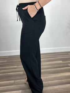 Side view of the front and back pockets on the black women's Kennedy elastic waist dress pants.