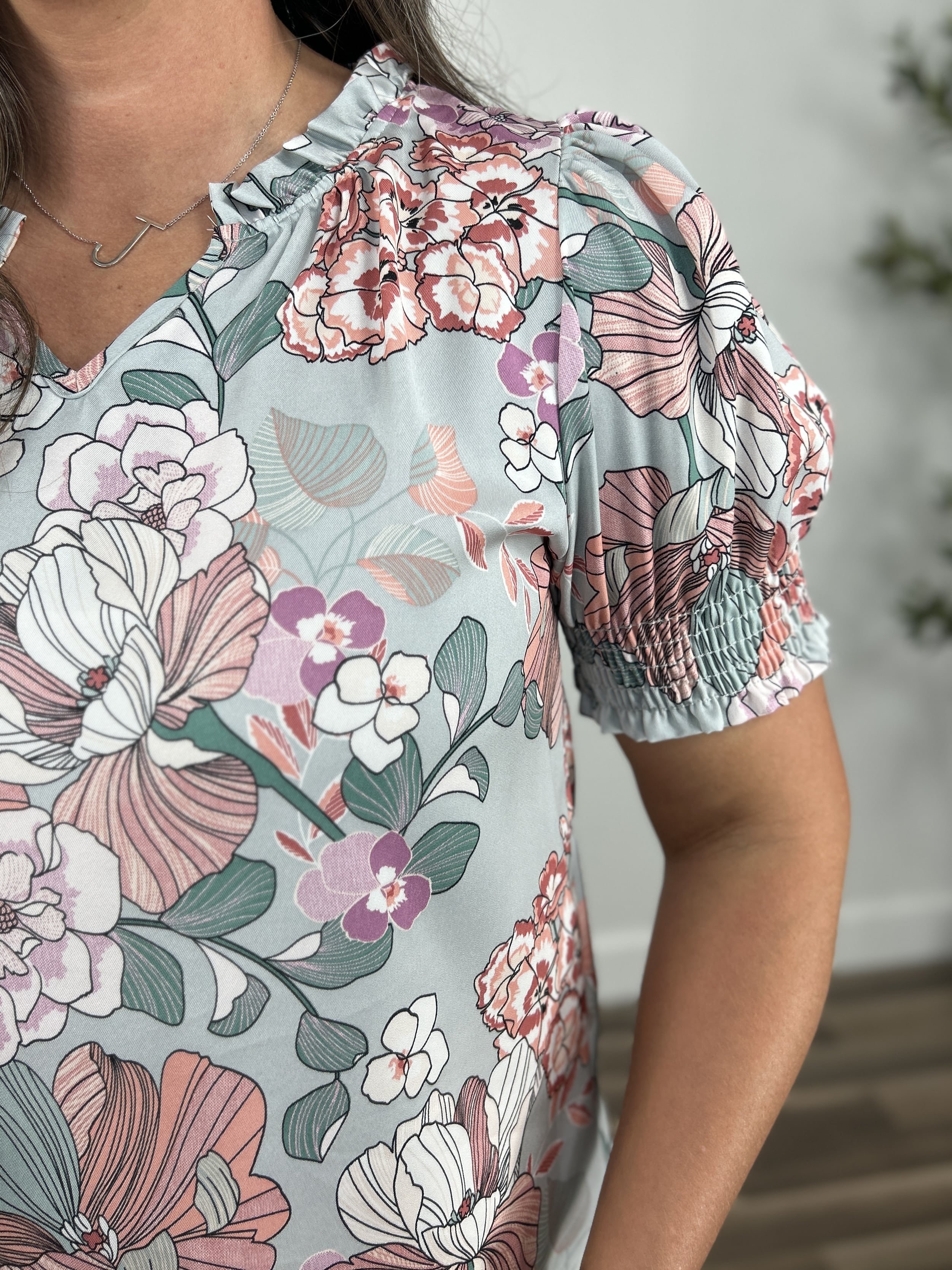 Upclose view of the smocking detail on the women's floral print top.