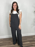 Load image into Gallery viewer, Women&#39;s charcoal ribbed comfort jumpsuit paired with flutter sleeve white top and black wedge sandals.
