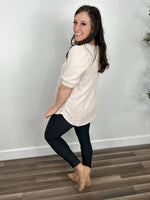 Load image into Gallery viewer, Side view of the women&#39;s lacy cable knit top in oatmeal paired with skinny pants and flat shoes.
