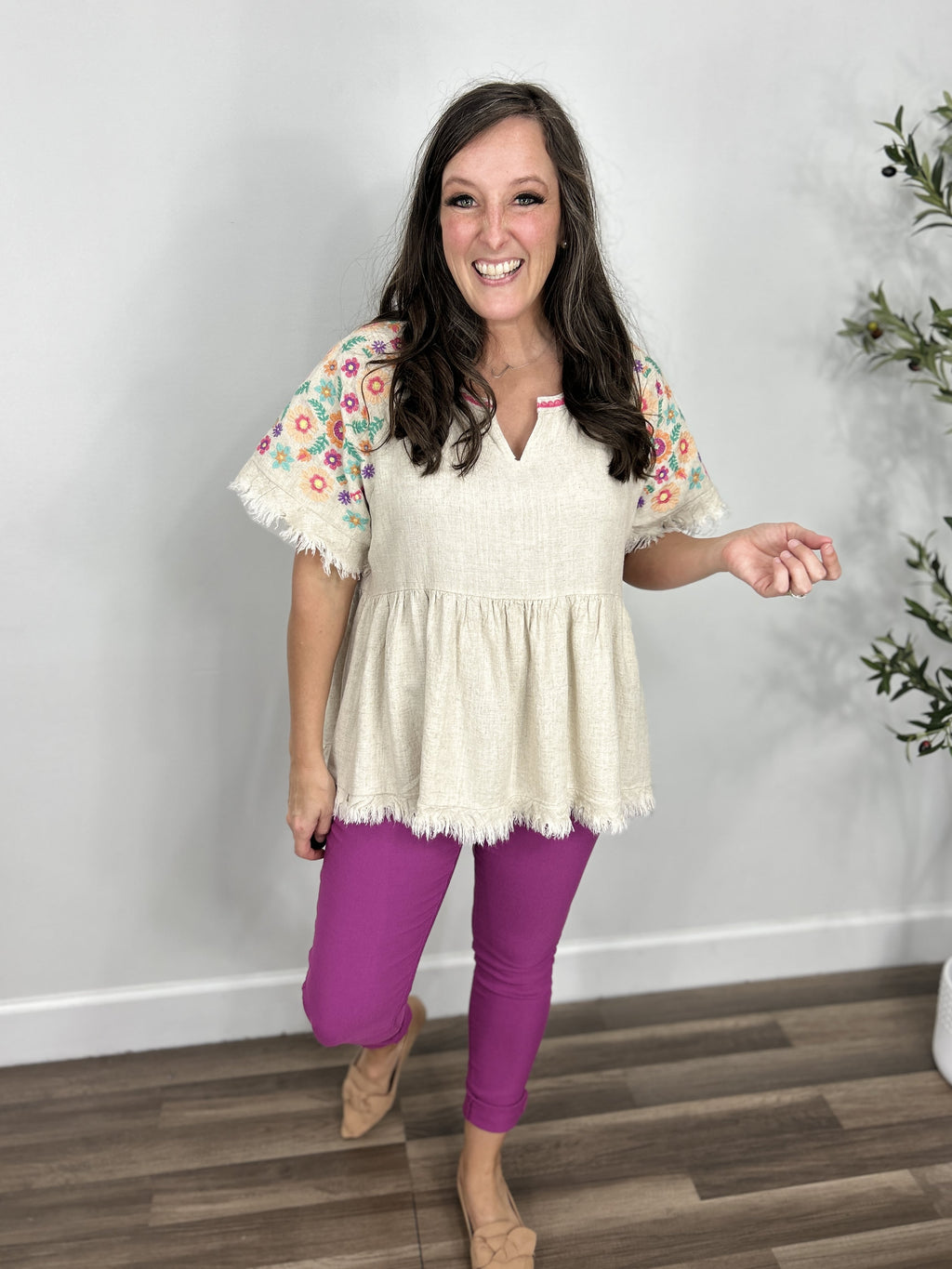 Laura embroiled floral sleeve babydoll top paired with fuchsia skinny jeans and flat camel color shoes.