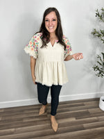 Load image into Gallery viewer, Outfit Styled- women&#39;s oatmeal color babydoll top with v neckline with embroidered flowers on short sleeves paired with charcoal skinny jeans and flat shoes.
