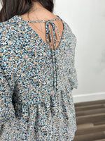 Load image into Gallery viewer, detailed view of the back of the women&#39;s floral top with a back v dip and a adjustable tie.
