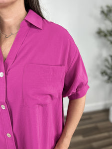 Upclose detail view of the Meg Magenta button up top showing chest pocket, puff short sleeves, and v neck collar.