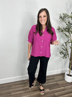Load image into Gallery viewer, Outfit styled with the women&#39;s meg magenta button up short sleeve top paired with black denim and black wedge sandals.
