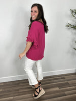 Load image into Gallery viewer, Side and back view of the Meredith linen ruffle sleeve top in hot pink with white crop flare pants and black sandals.
