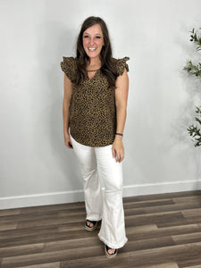 Monica leopard print ruffle sleeve top paired with white flare pants and black wedge sandals.