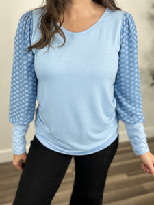 Sanders dot sleeve round neck top upclose view of blue color, round neckline, and contrasting dotted sleeves.
