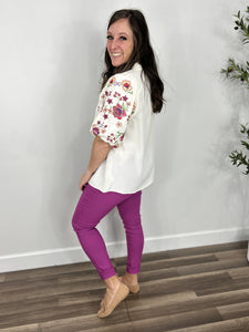 Back and side view of the Savannah Floral Puff Sleeve Top with skinny jeans in a berry color.