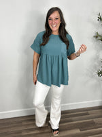 Load image into Gallery viewer, Women&#39;s Whitney short sleeve babydoll top in teal paired with the Olivia stretchy flare jeggings in white with black wedge sandals.
