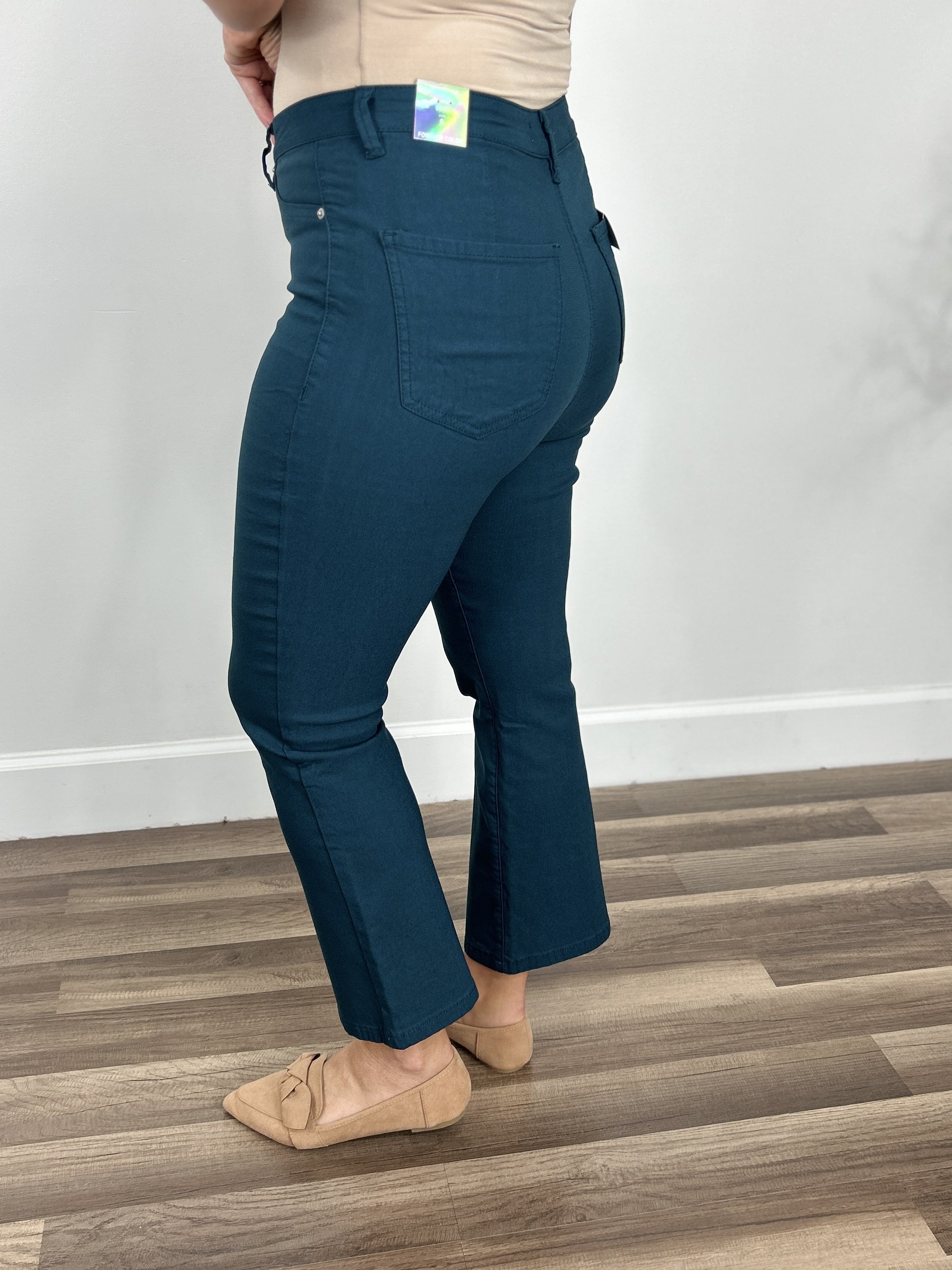 Side view of the Wyatt stretch flare crop pants in teal with back functioning packets.